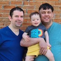 Dads smiling with their son with Down syndrome