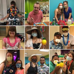 Nine adults with Down syndrome wearing beach themed clothes at GiGi's Playhouse Annapolis