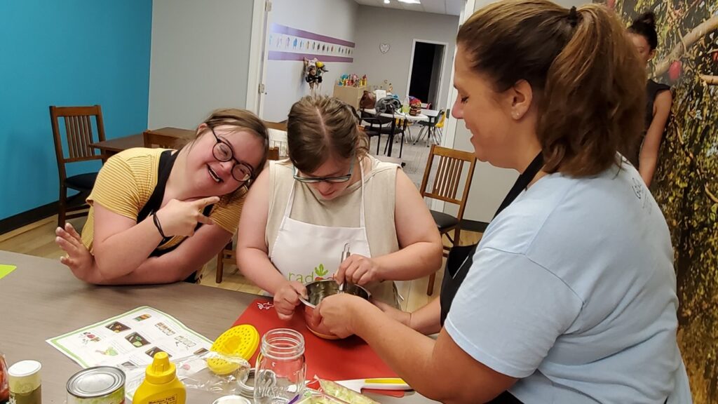 Picture shows adults in the kitchen working together
