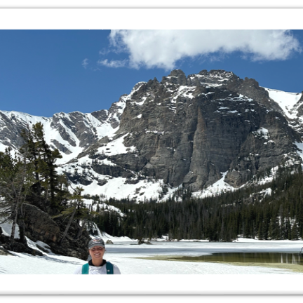 Girl standing in front of a mountain the background