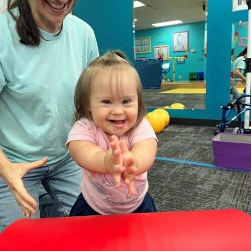 Young girl with Down syndrome clapping and smiling