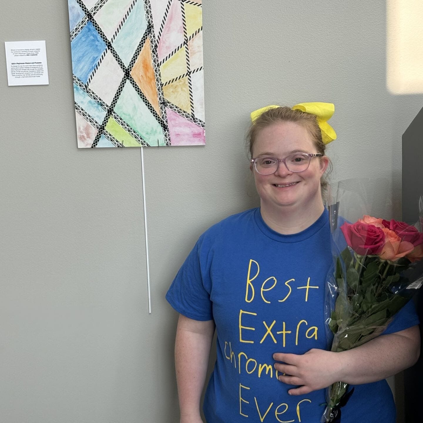 A female with bouquet of flowers standing in front of painting.