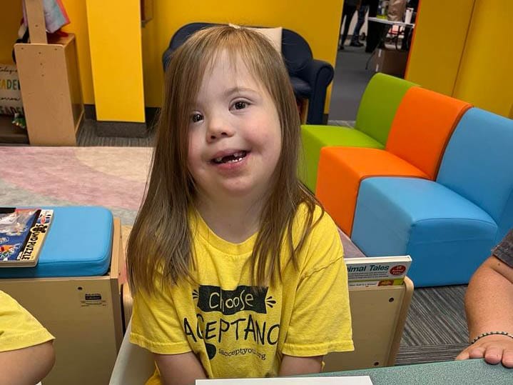 Little girl in a yellow shirt smiling