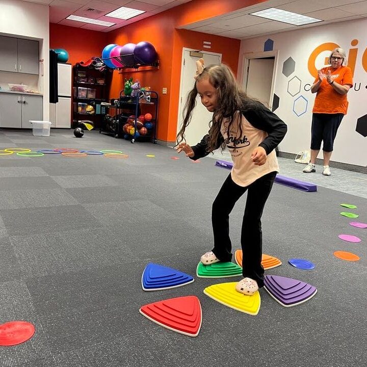 a child with Down syndrome balances in obstacle course