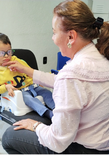 Female in white shirt playing with kid with down syndrome