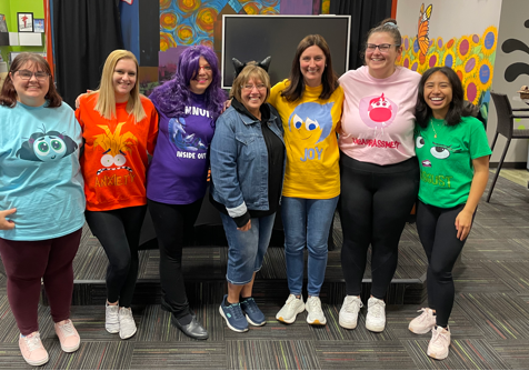Group of smiling women dressed as characters from the Disney movie, Inside Out