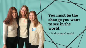 Mom and daughters stand next to inspirational quote