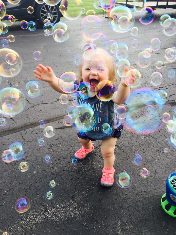 little girl with Down syndrome playing in bubbles