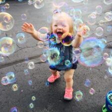 little girl with Down syndrome playing in bubbles