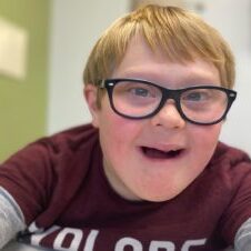 Little boy with Down syndrome wearing glasses and smiling