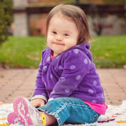 baby girl with Down syndrome smirking