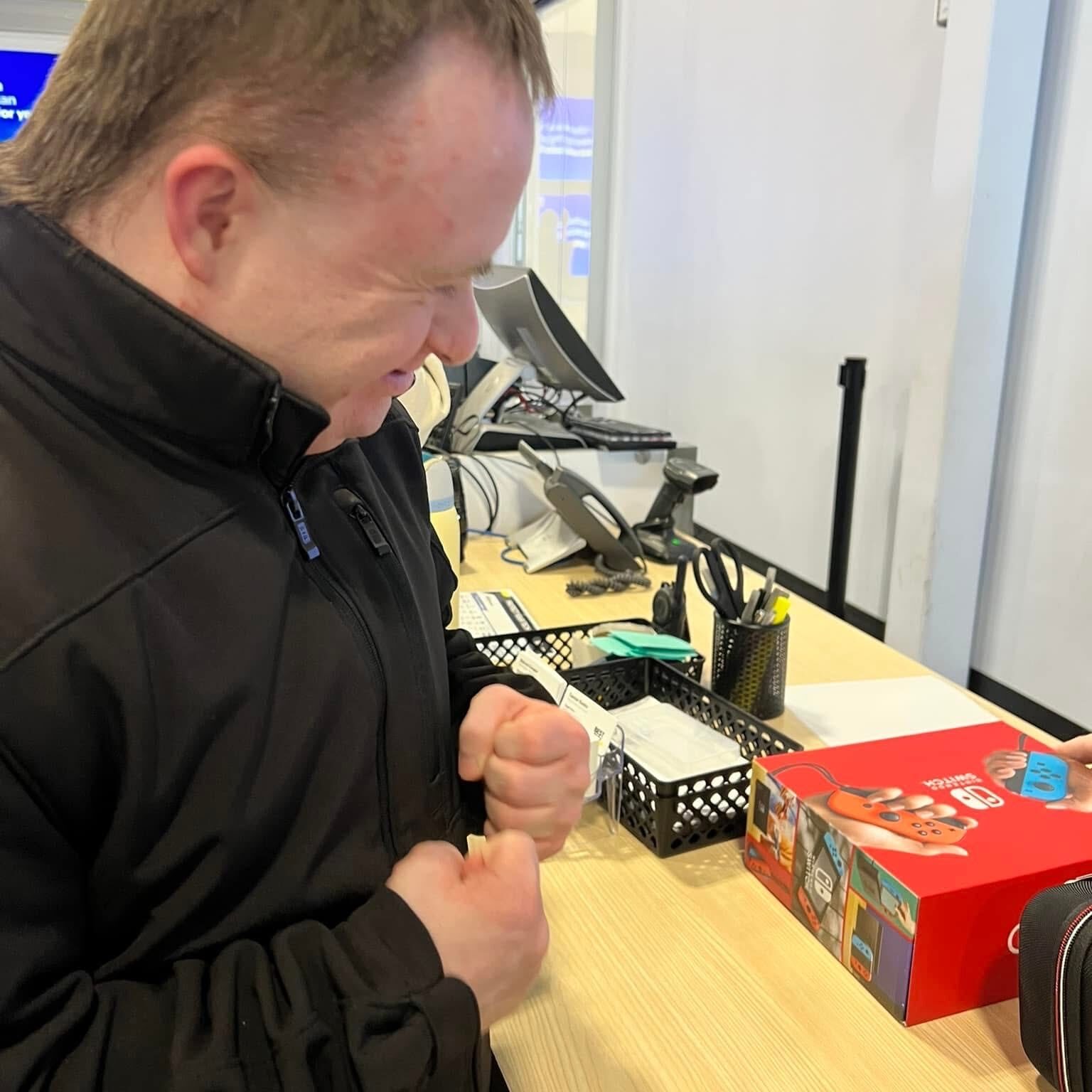 A man with Down syndrome who is excited buying a nintendo switch
