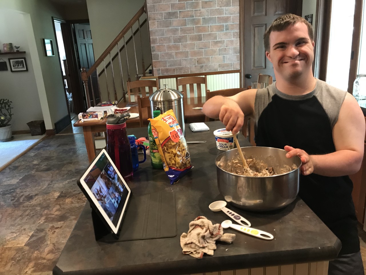 adult man with DOwn syndrome cooking with GiGi's Playhouse virtual Programs