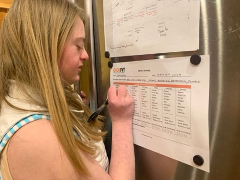 Girl with Down syndrome filling out fitness tracker