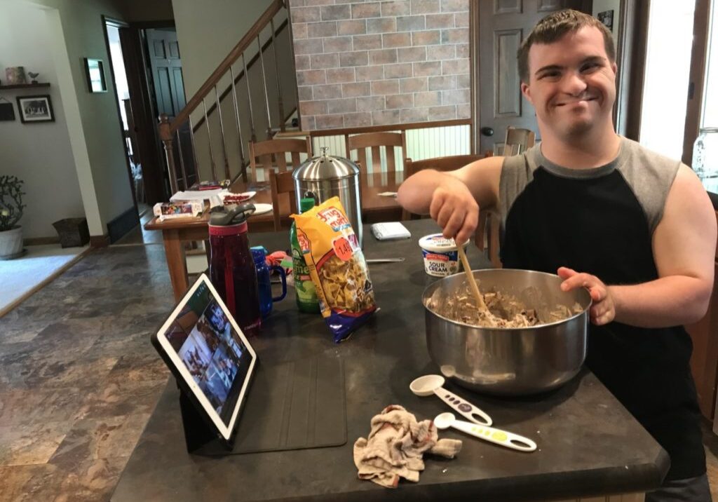 adult man with DOwn syndrome cooking with GiGi's Playhouse virtual Programs